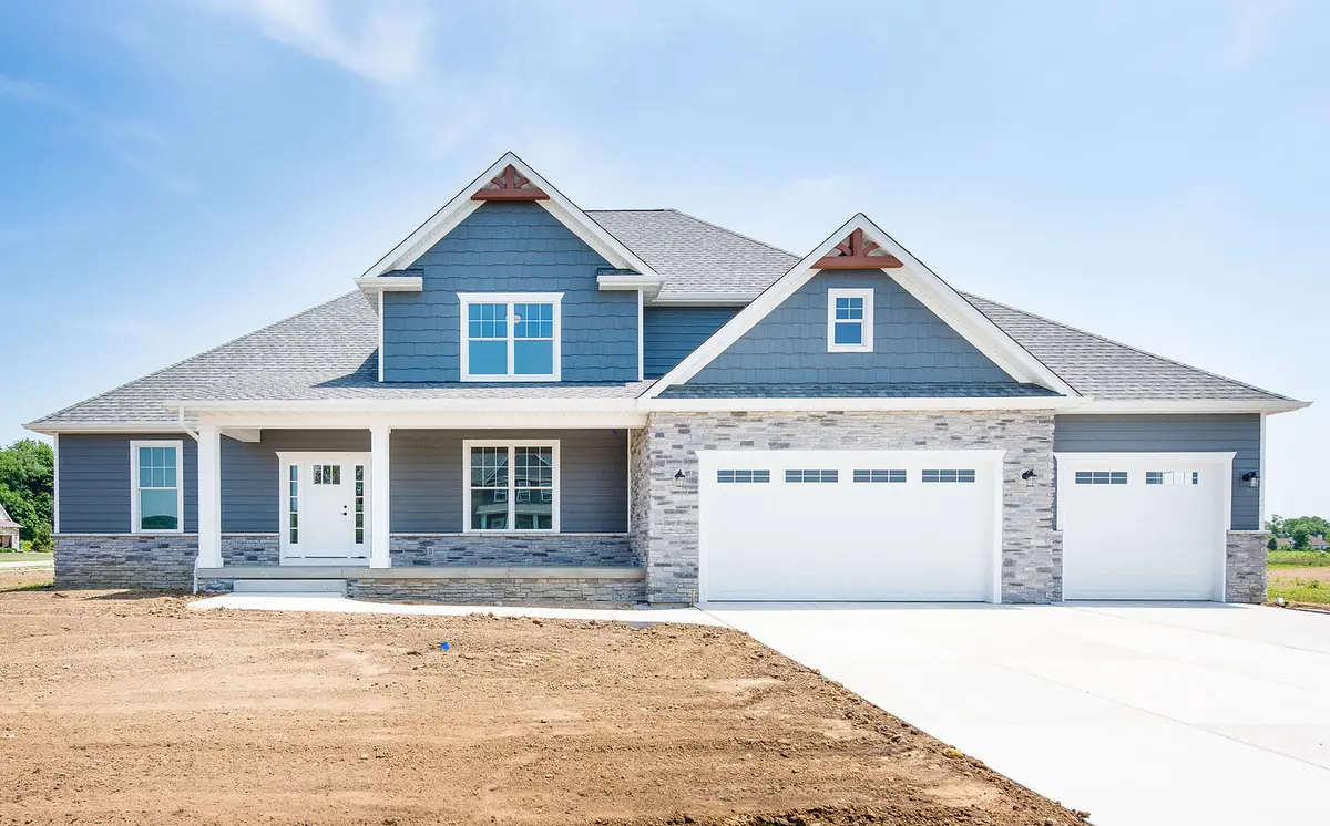 Blue craftsman with stone accents and triple garage