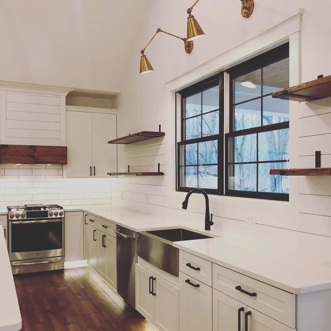 Farmhouse sink wall with apron-front sink, brass sconces and floating shelves