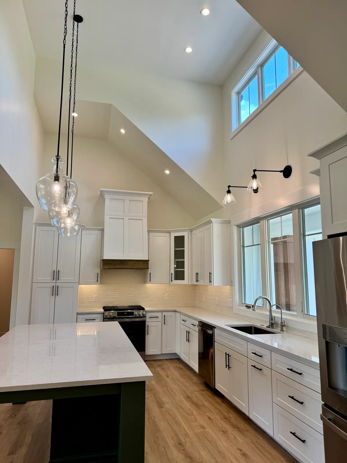 Vaulted kitchen ceiling with clerestory windows and glass pendants over the island