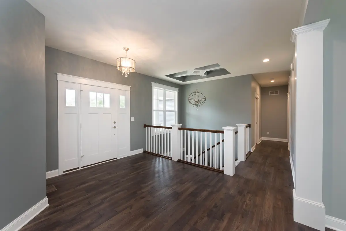 Empty room with hardwood floors and large windows