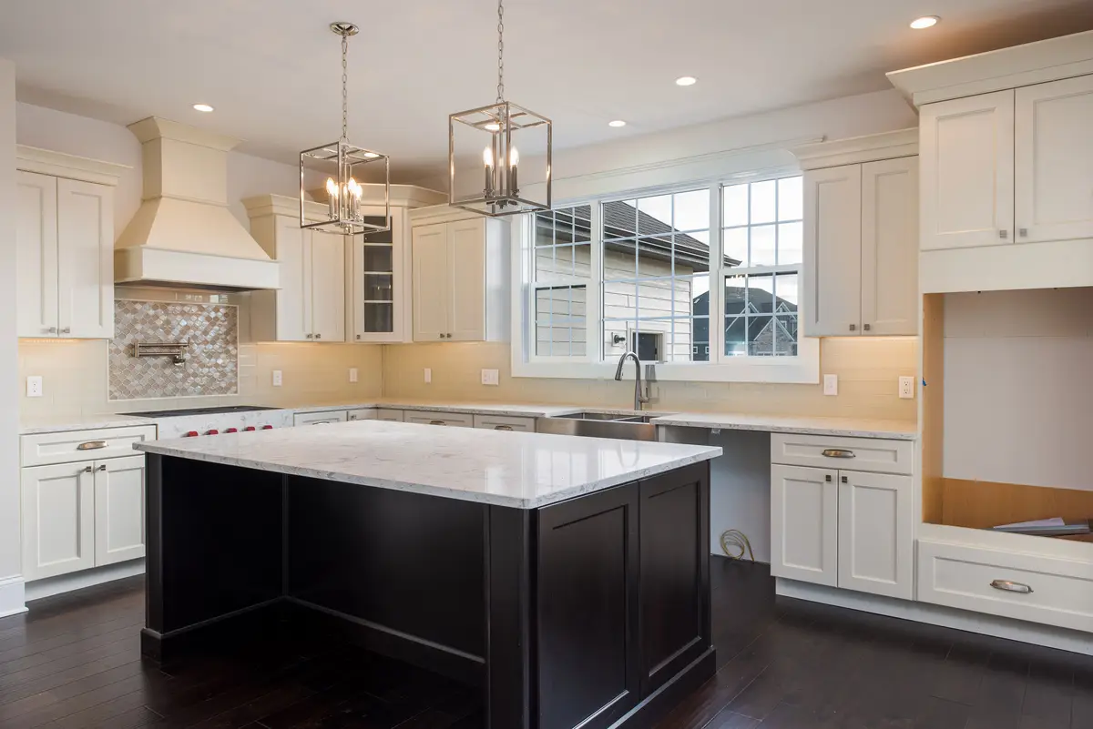 Kitchen with custom range hood and contrast island