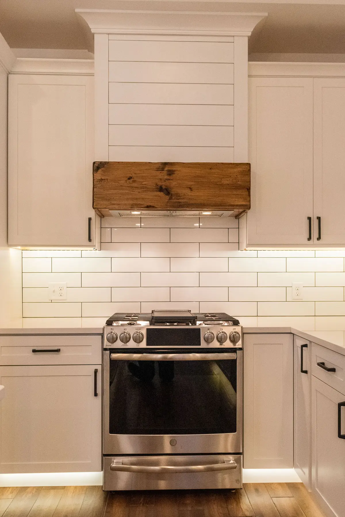 Stainless range with subway tile and reclaimed-wood hood