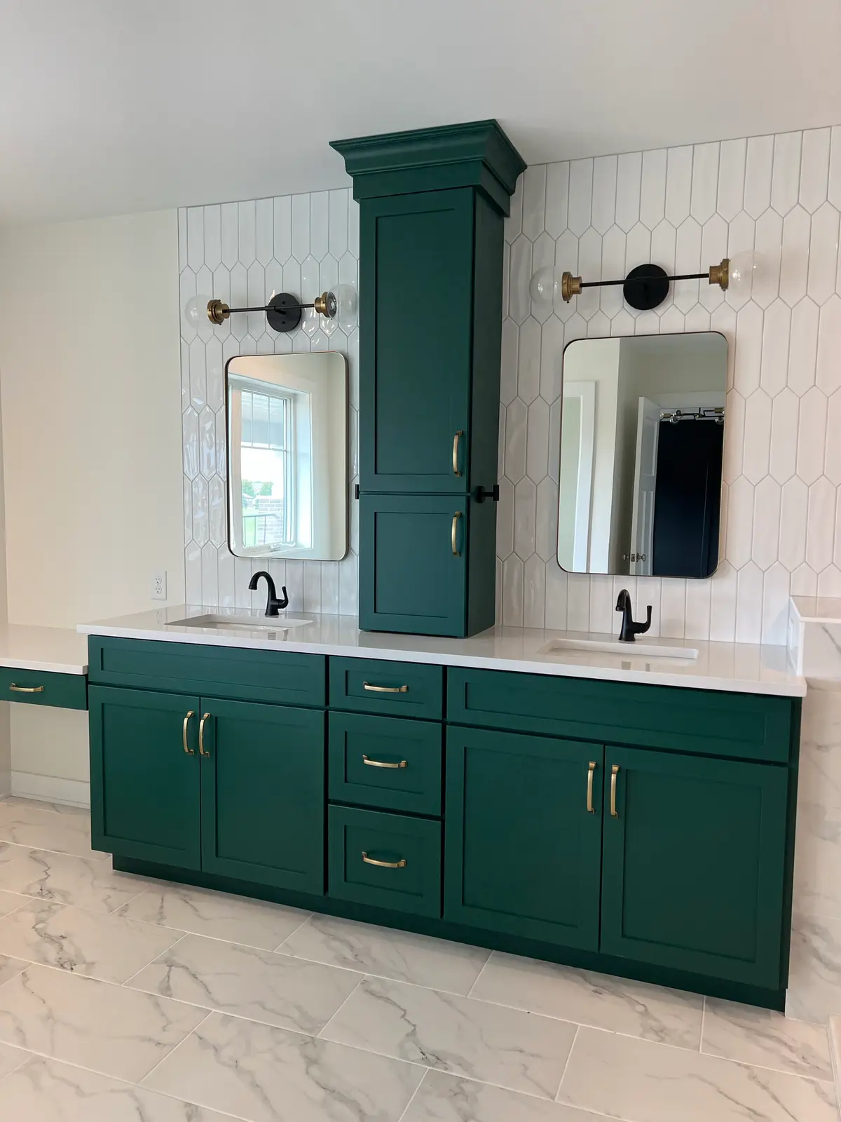 Dark green double vanity with brass hardware and arched mirrors