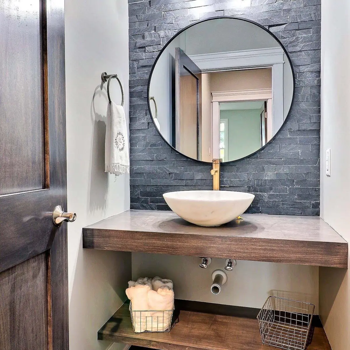 Powder room with vessel sink, brass faucet and stacked stone accent wall