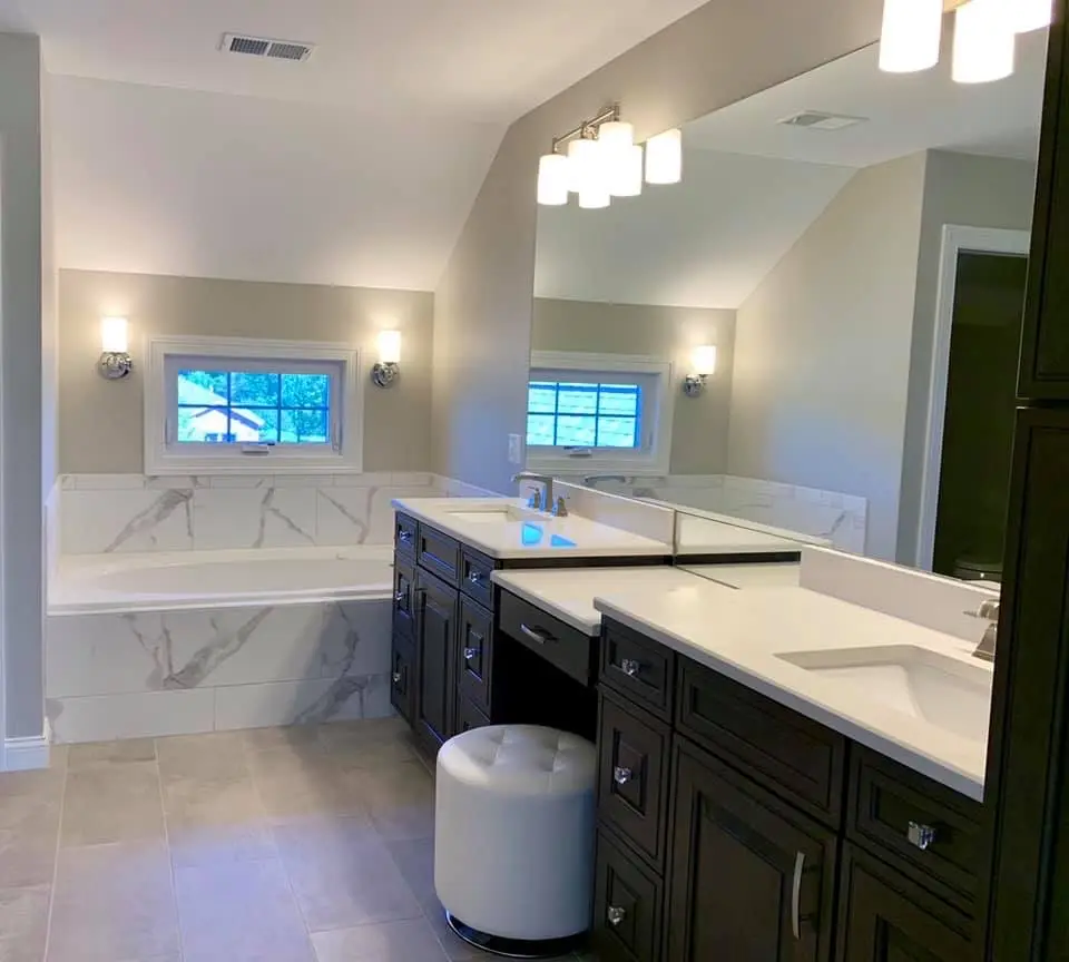 Master bath with marble tub surround, espresso double vanity and makeup seat