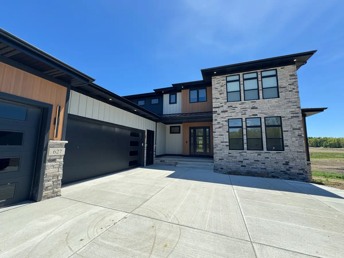 Modern two-story home with stone, cedar and white siding and black windows