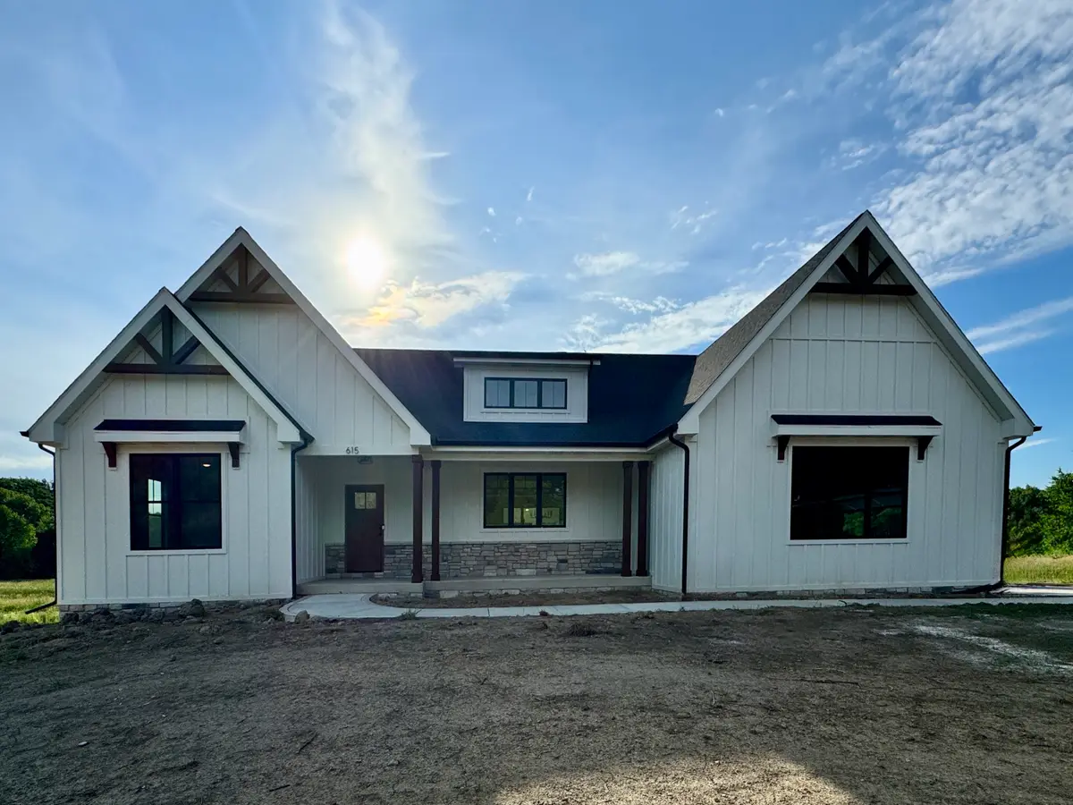 White board-and-batten farmhouse with twin gables and covered front porch