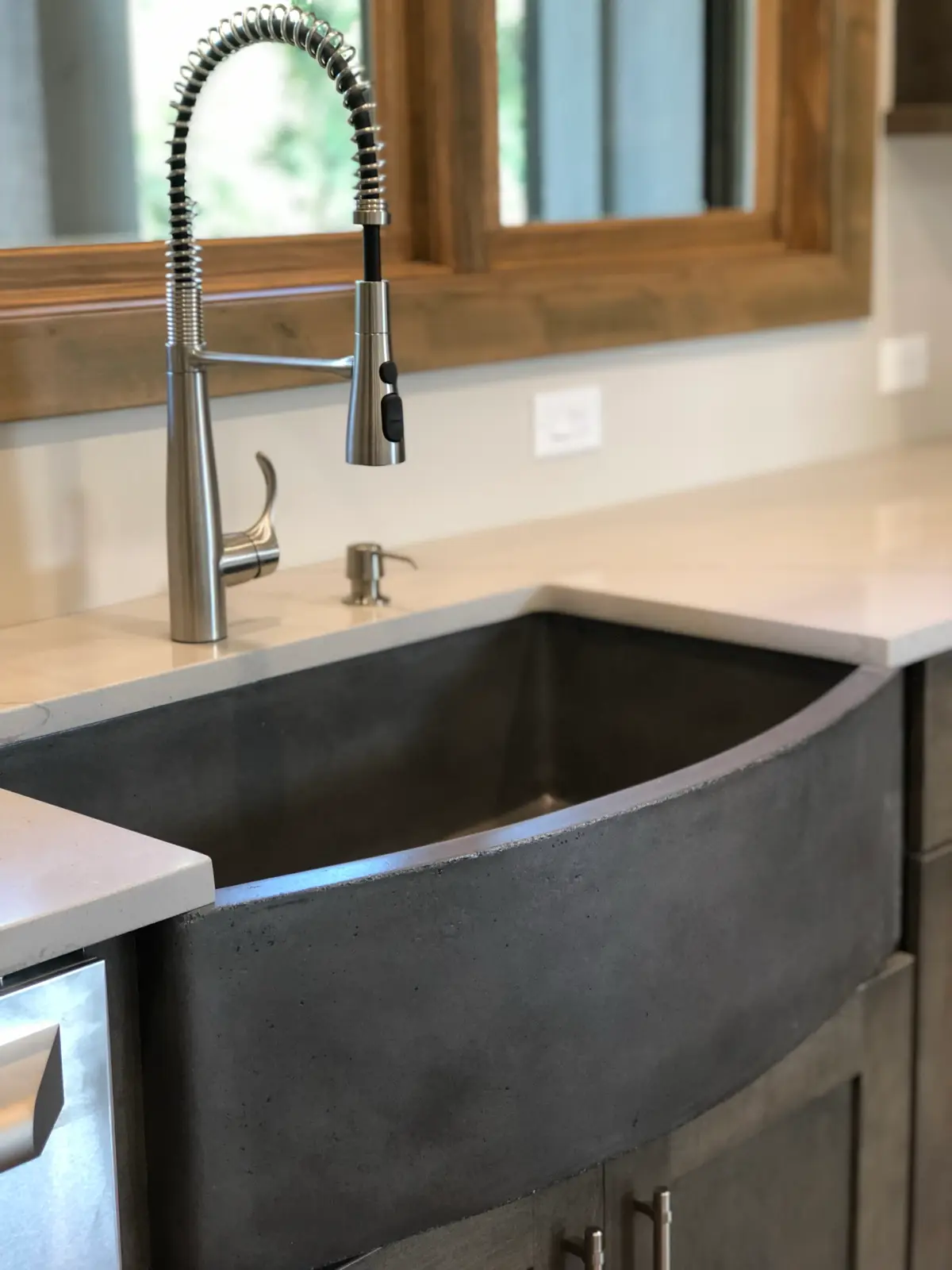 Concrete farmhouse apron sink with coil pull-down faucet and white quartz